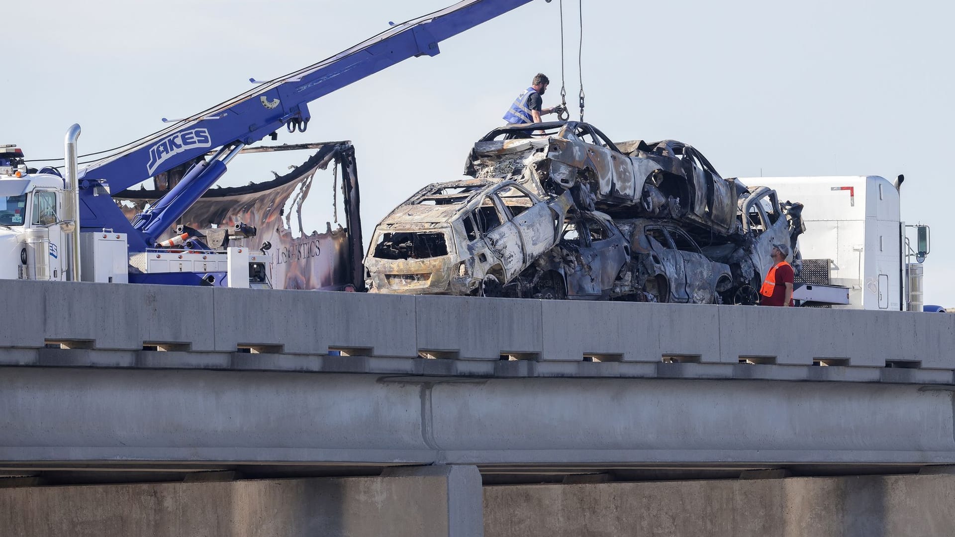 Arbeiter räumen die Wracks dutzender Autos von der Interstate 55.