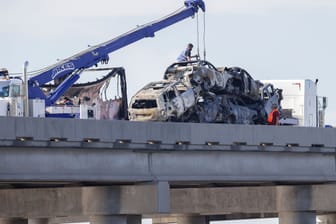 Arbeiter räumen die Wracks dutzender Autos von der Interstate 55.