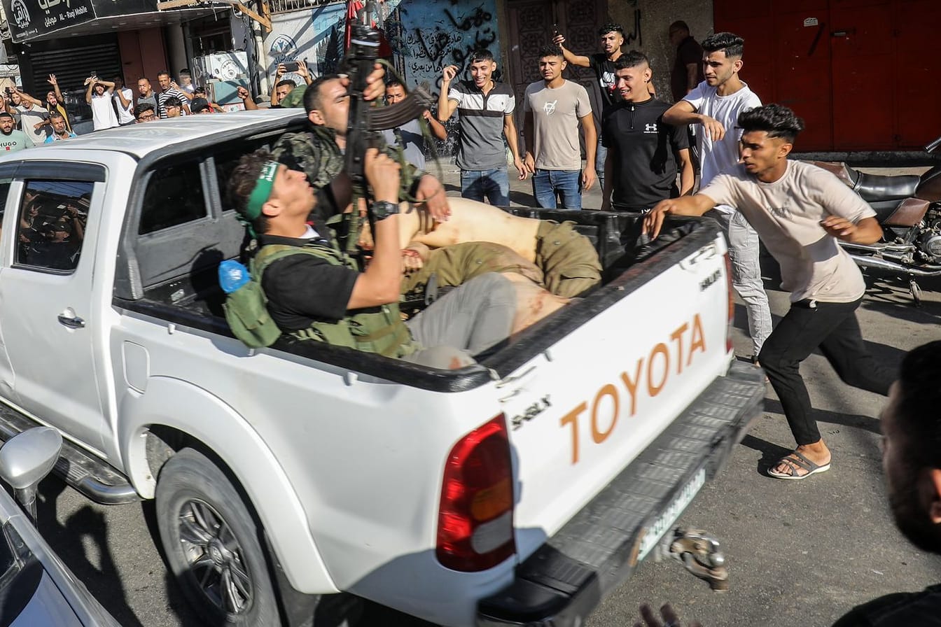 Militante Palästinenser umringen einen Lastwagen, der angeblich einen gefangenen Israeli transportiert.