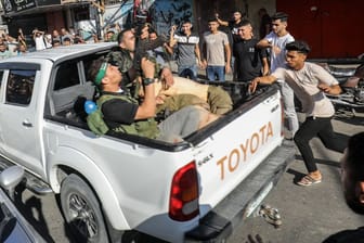 Militante Palästinenser umringen einen Lastwagen, der angeblich einen gefangenen Israeli transportiert.