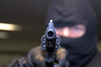 Maskierter Mann mit Schusswaffe (Symbolbild): Maskierter Mann mit Schusswaffe (Symbolbild):