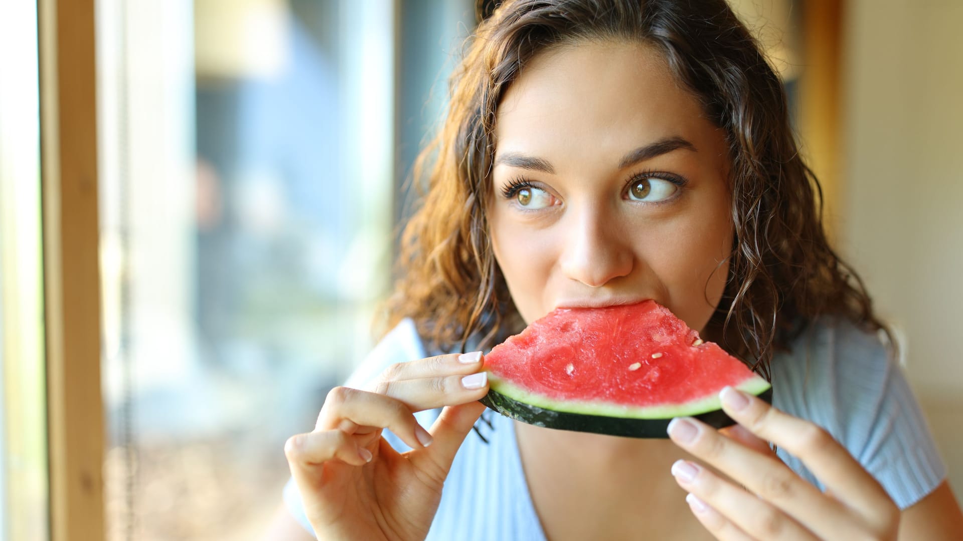 Frau isst ein Stück Wassermelone