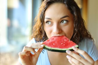 Frau isst ein Stück Wassermelone