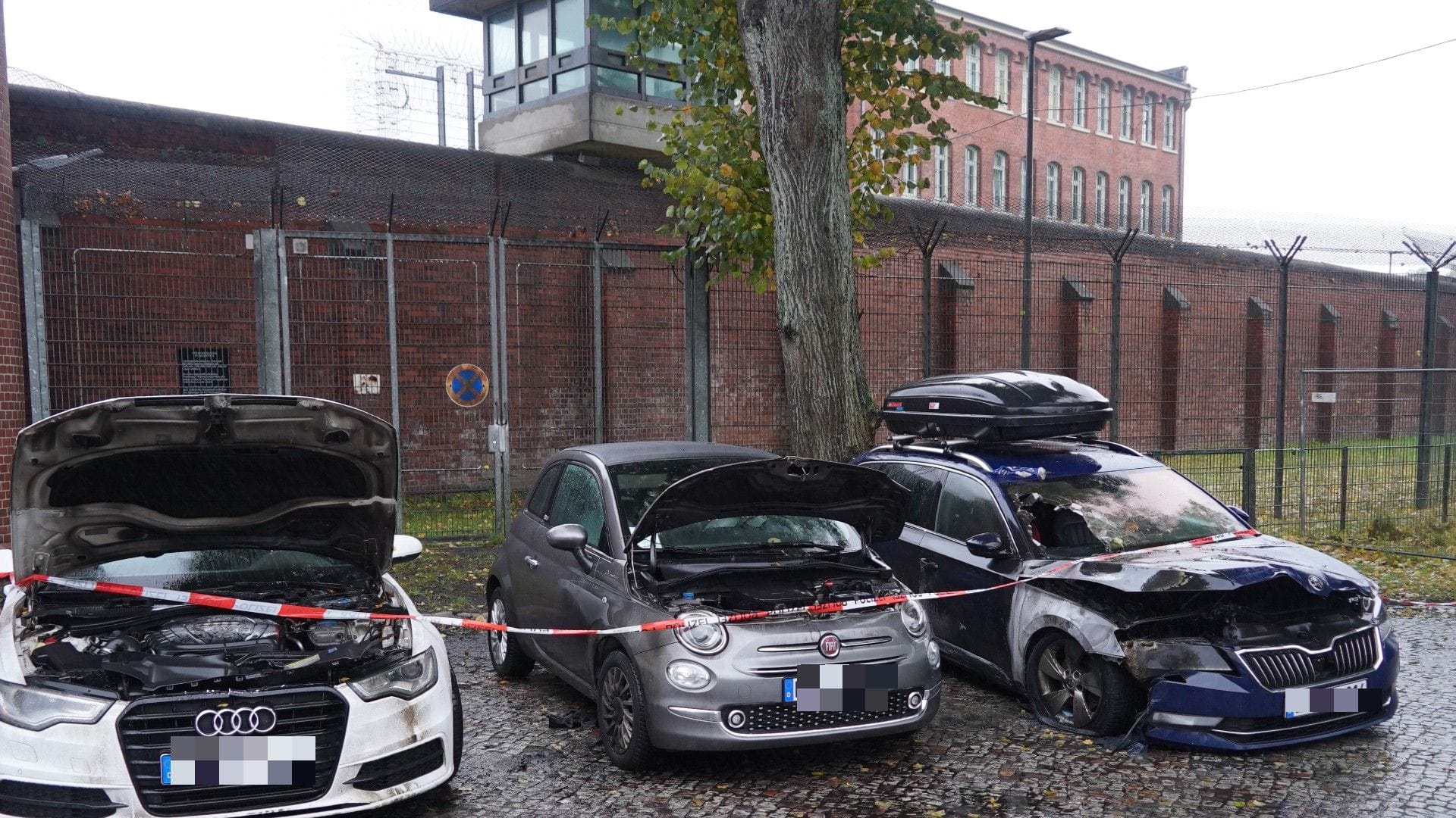 Die schwer beschädigten Privatwagen: Sie parkten direkt neben dem Gefängnistor. Die schwer beschädigten Privatwagen: Sie parkten direkt neben dem Gefängnistor.