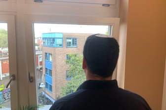 Israeli Avinoam blickt aus einem Fenster auf eine Kölner Straße. Er will für sein Land kämpfen.