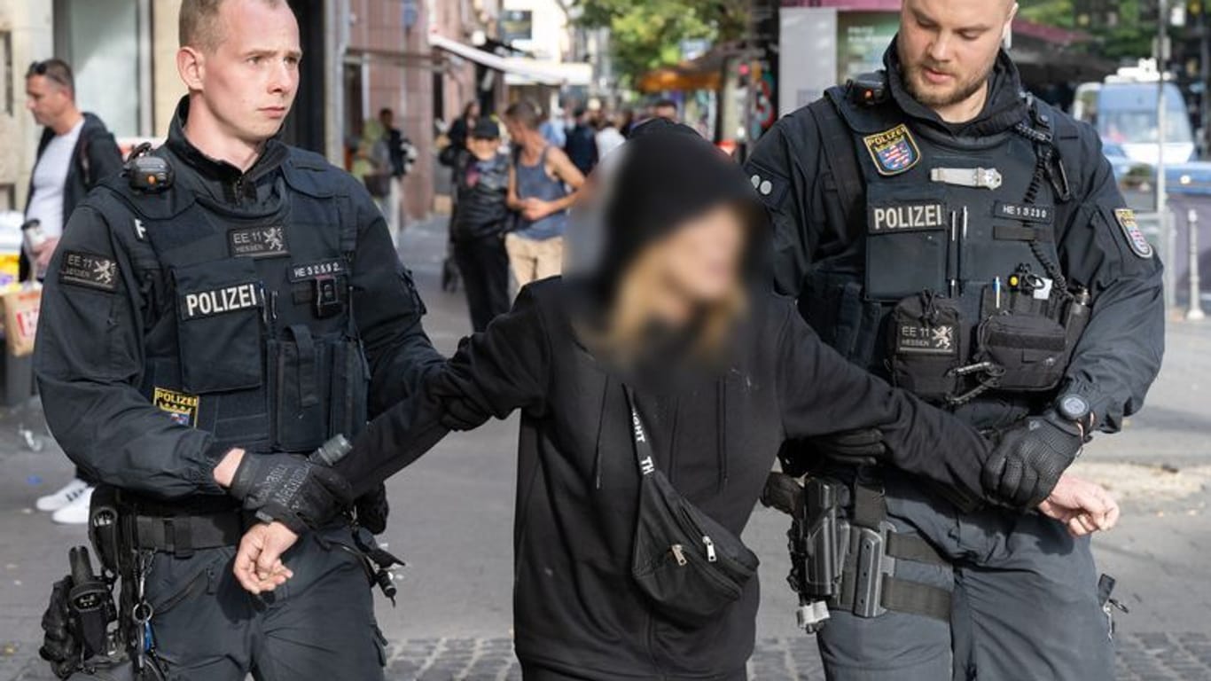 Beamte einer Polizeieinheit führen im Bahnhofsviertel von Frankfurt eine Verdächtige ab (Archivbild).
