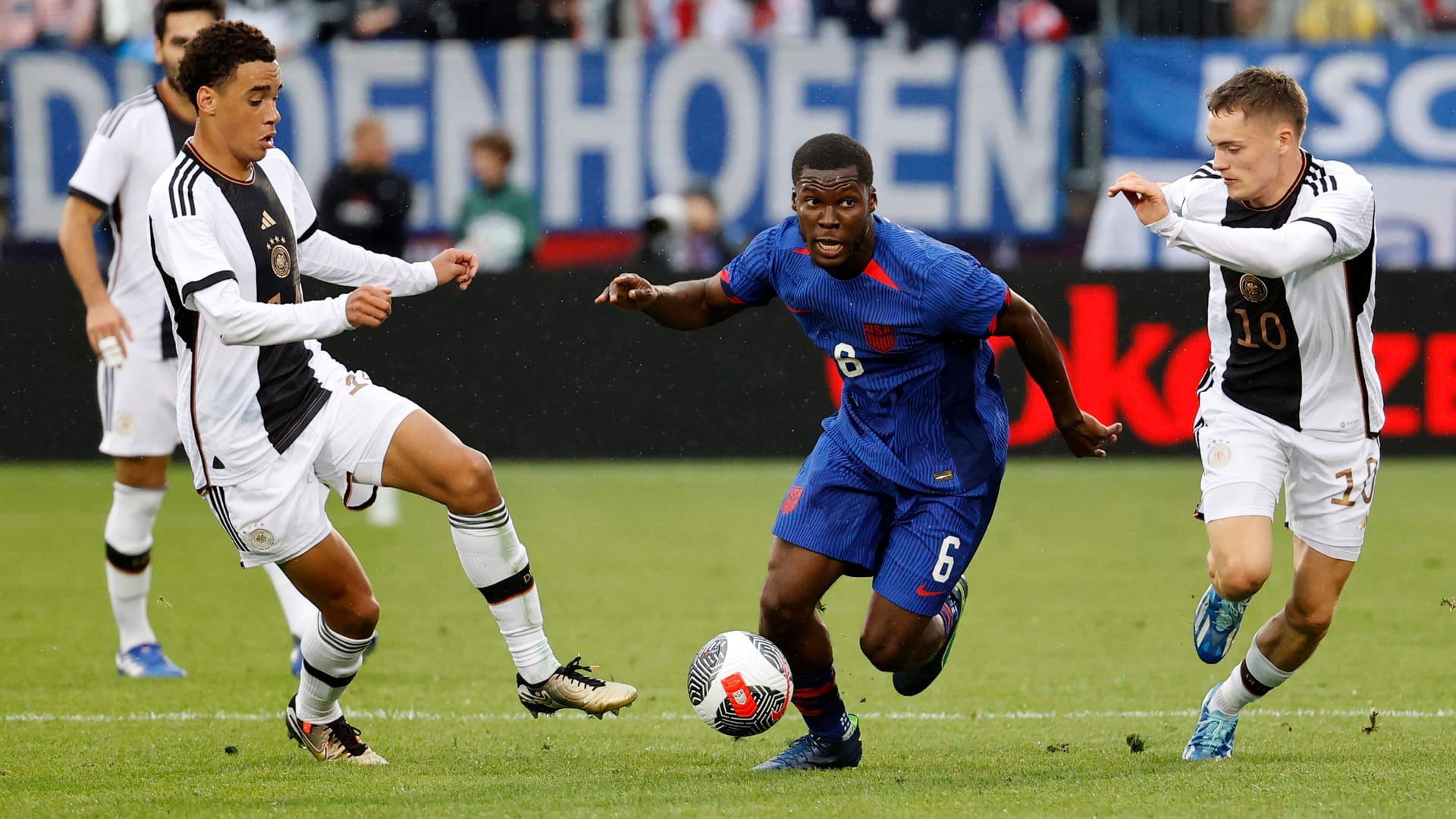 Jamal Musiala (li.) und Florian Wirtz nehmen Yunus Musah in die Zange.