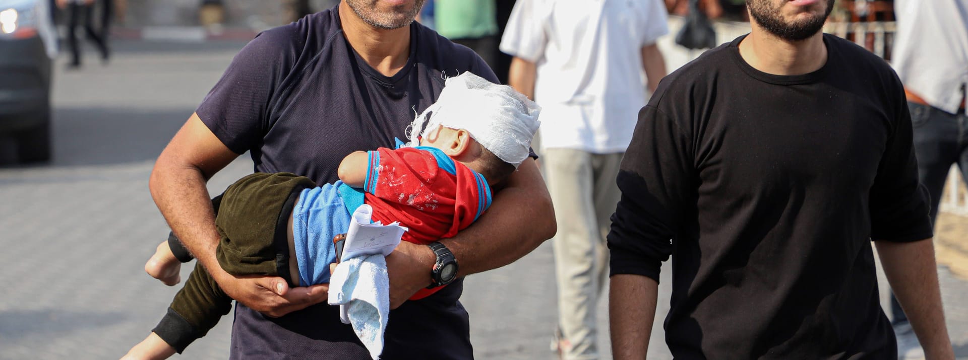 Ein Mann trägt ein verletztes Kind in ein Krankenhaus in Gaza: Bei israelischem Beschuss sind hunderte Menschen gestorben und Tausende verletzt.