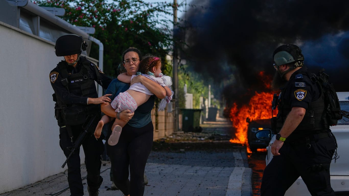 Sicherheitskräfte im israelischen Ashkelon bringen eine Familie vor Angriffen aus dem Gaza-Streifen in Sicherheit.