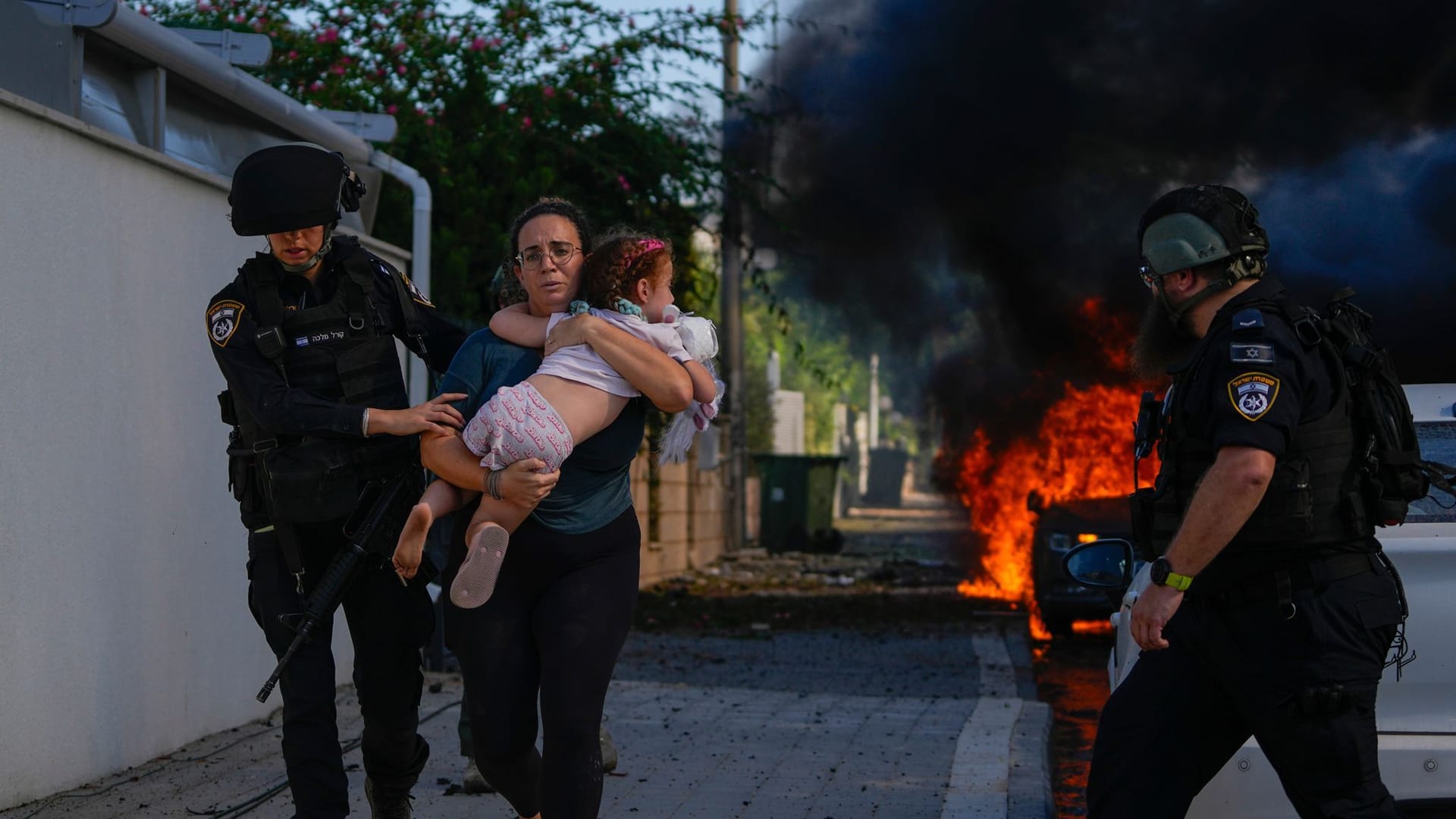 Sicherheitskräfte im israelischen Ashkelon bringen eine Familie vor Angriffen aus dem Gaza-Streifen in Sicherheit.