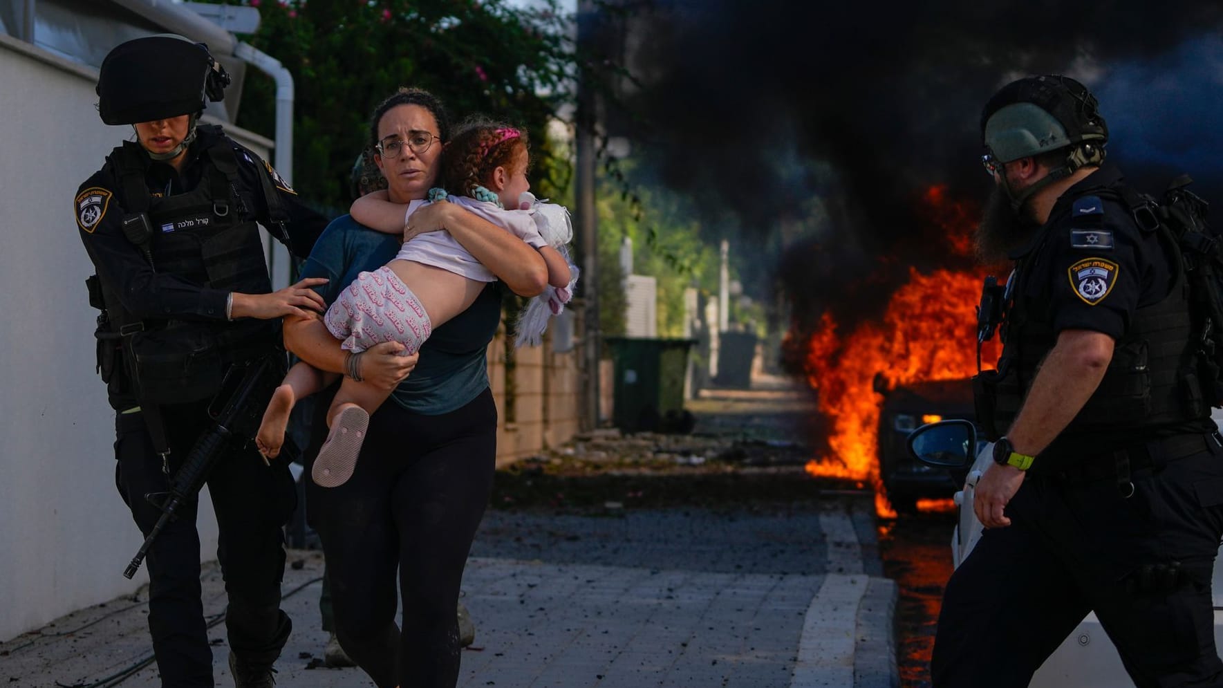 Sicherheitskräfte im israelischen Ashkelon bringen eine Familie vor Angriffen aus dem Gaza-Streifen in Sicherheit.