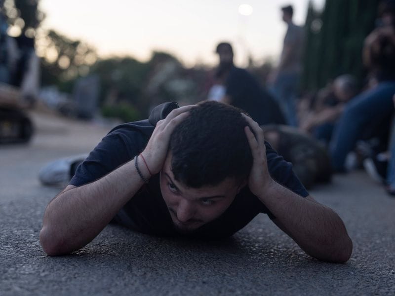Raketenalarm während einer Beerdigung: Ein Israeli sucht Schutz vor tödlichen Geschossen, die aus Gaza kommen.