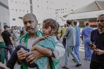 Mann in Gaza hält ein verletztes Kind (Archivbild): Die Hamas behauptet, die Aufforderung der israelischen Armee sei Propaganda und hindert die Menschen am Verlassen von Gaza-Stadt.