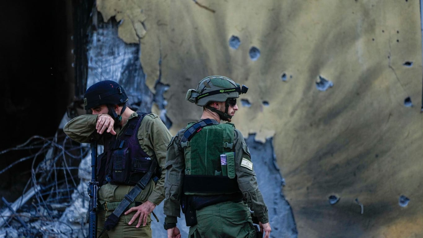 Israelische Soldaten inspizieren den zerstörten Kibbutz Be'eri nach dem Hamas-Angriff.