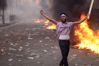 Demonstrant steht während Ausschreitungen in Dhaka vor einer brennenden Barrikade: Zu dem Protest für faire und freie Wahlen kamen über 100.000 Menschen.