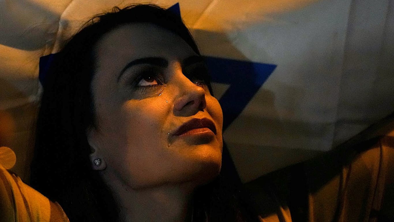 Sie hat es geschafft: Mit einer Fahne in den Händen kommt eine Brasilianerin in ihrem Heimatland an und weint, nachdem sie von der brasilianischen Luftwaffe aus dem Kriegsgebiet geflogen wurde.