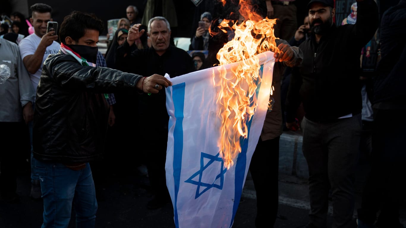 Demonstranten im Iran verbrennen eine israelische Fahne: Der Präsident hetzte bei einem Massenprotest in Teheran gegen Israel und die USA.
