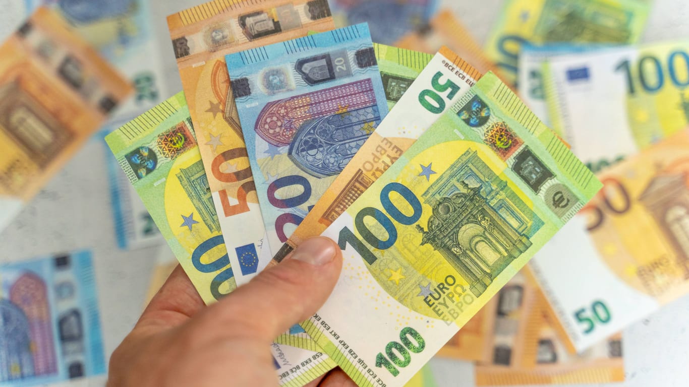 Mehrere Euro-Scheine in der Hand einer Person (Symbolbild): Diese Menschen haben mehr Geld für Konsum und Sparen als andere Niedersachsen.