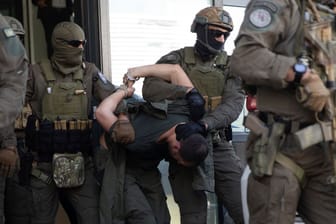 Kosovarische Polizeibeamte führen Serben ab, die an dem Angriff beteiligt gewesen sein sollen: Der Konflikt spitzt sich zu.