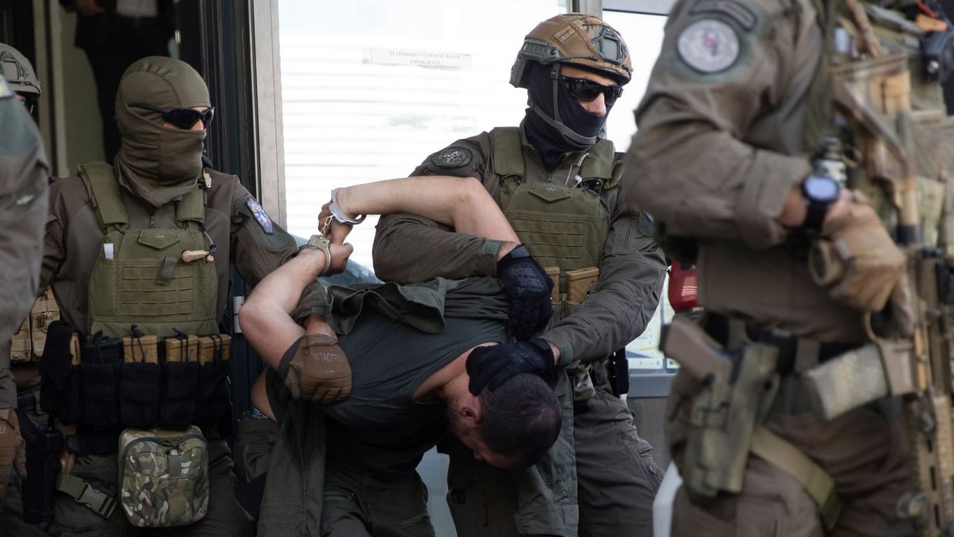 Kosovarische Polizeibeamte führen Serben ab, die an dem Angriff beteiligt gewesen sein sollen: Der Konflikt spitzt sich zu.