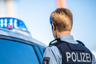 Eine Polizistin steht vor einem Streifenwagen (Symbolbild): Die Auto-Attacke in Duisburg konnte rekonstruiert werden.