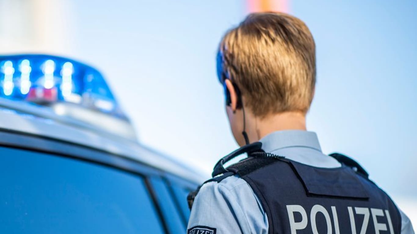 Eine Polizistin steht vor einem Streifenwagen (Symbolbild): Die Auto-Attacke in Duisburg konnte rekonstruiert werden.
