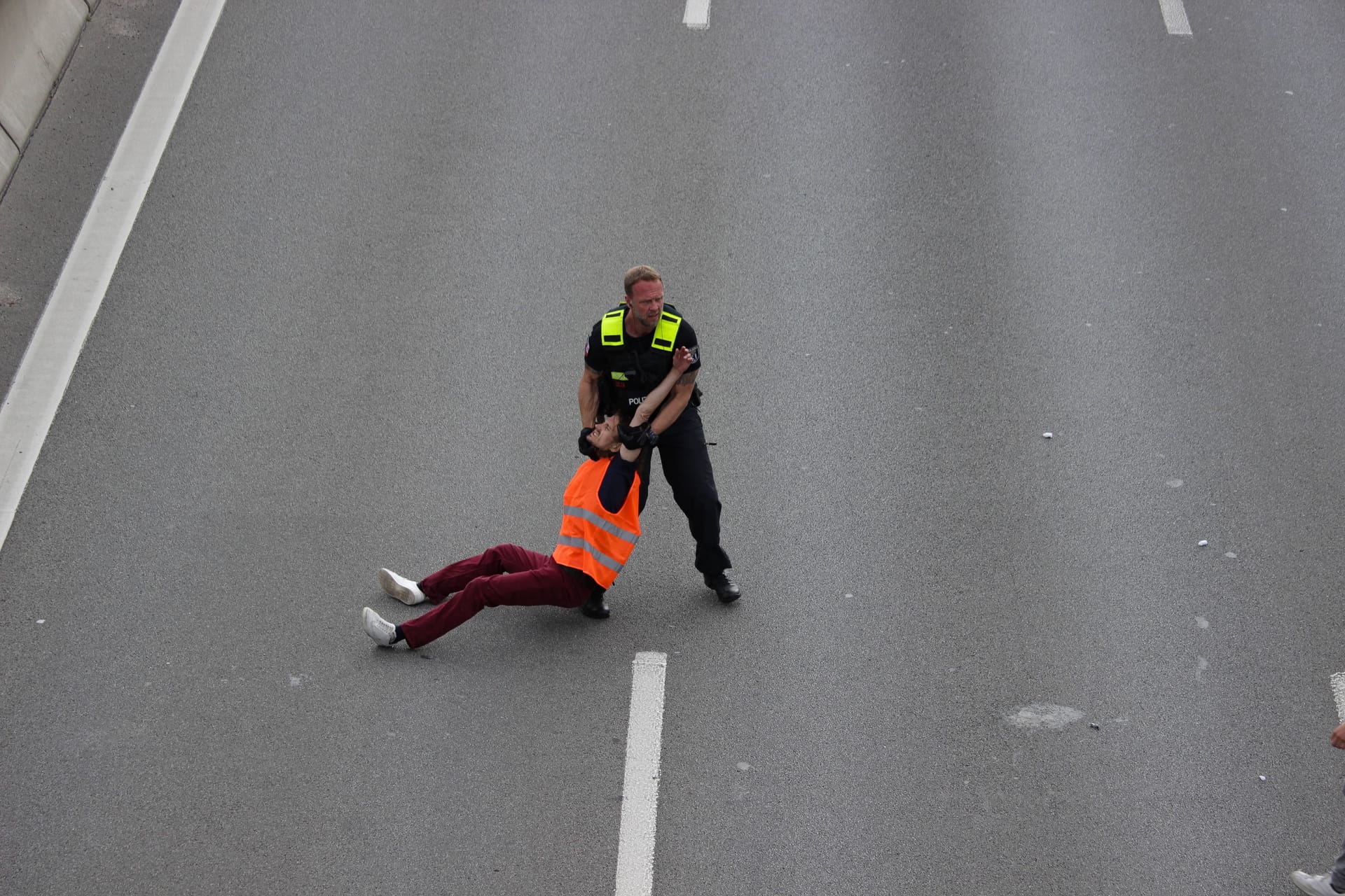 Ein Polizist zieht einen Klimaaktivisten von der A100 (Archivbild):