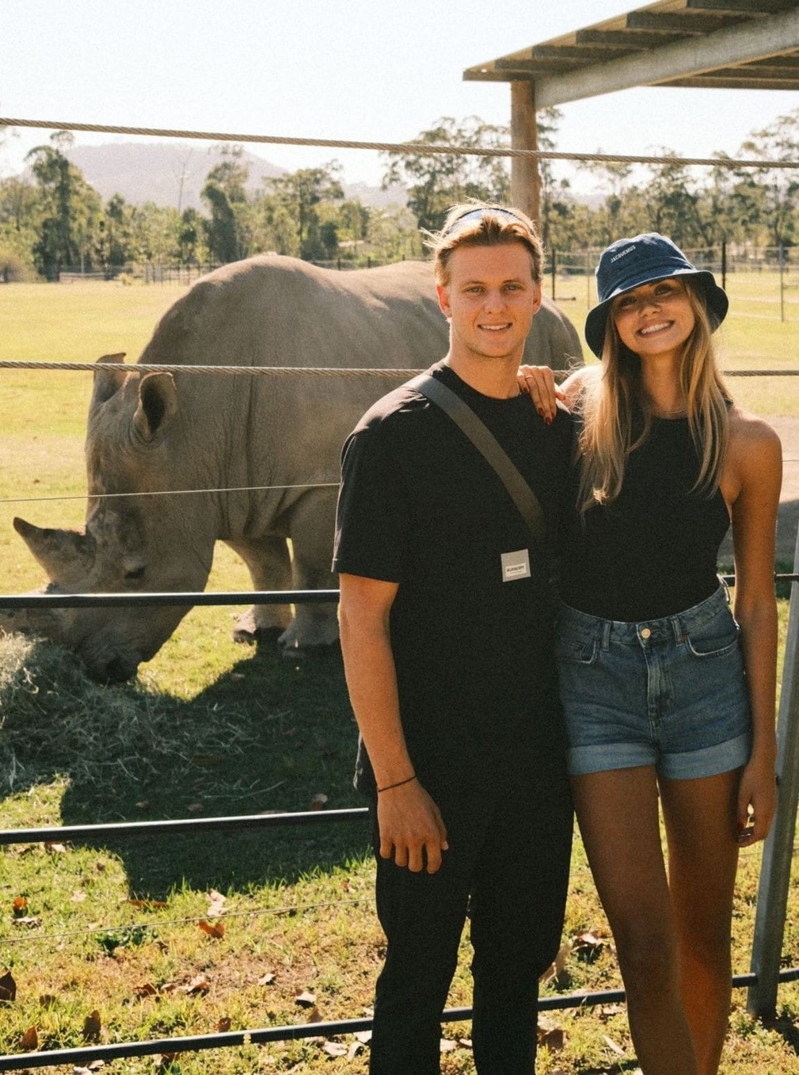 Mick Schumacher und Laila Hasanovic posieren vor einem Nashorn