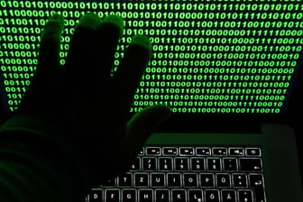 Grüner Binär-Code auf Bildschirm eines Laptops (Archivbild): Ein Verdacht der Ermittler hat sich nach mehreren Hackerangriffen in NRW bestätigt.