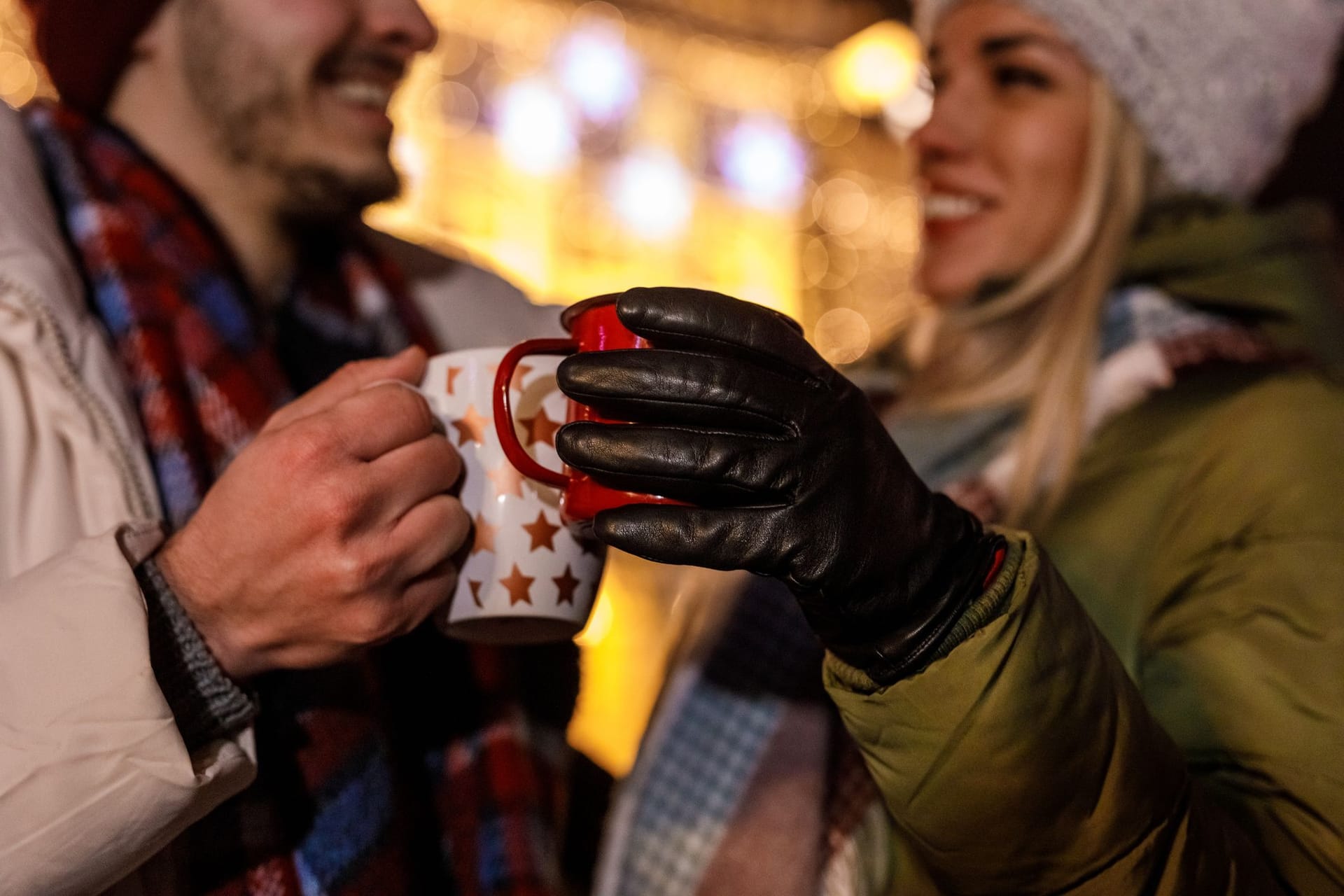 Weihnachtsmarktbesucher stoßen mit Glühwein an: Das Getränk wird traditionell in der Adventszeit getrunken.