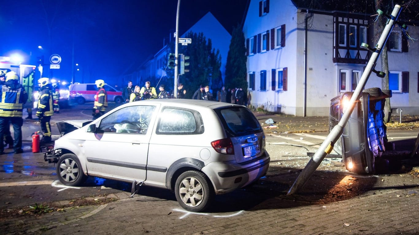 Einsatzkräfte an der Unfallstelle: Durch die Aufprallwucht war BMW auf die rechte Fahrzeugseite gekippt.
