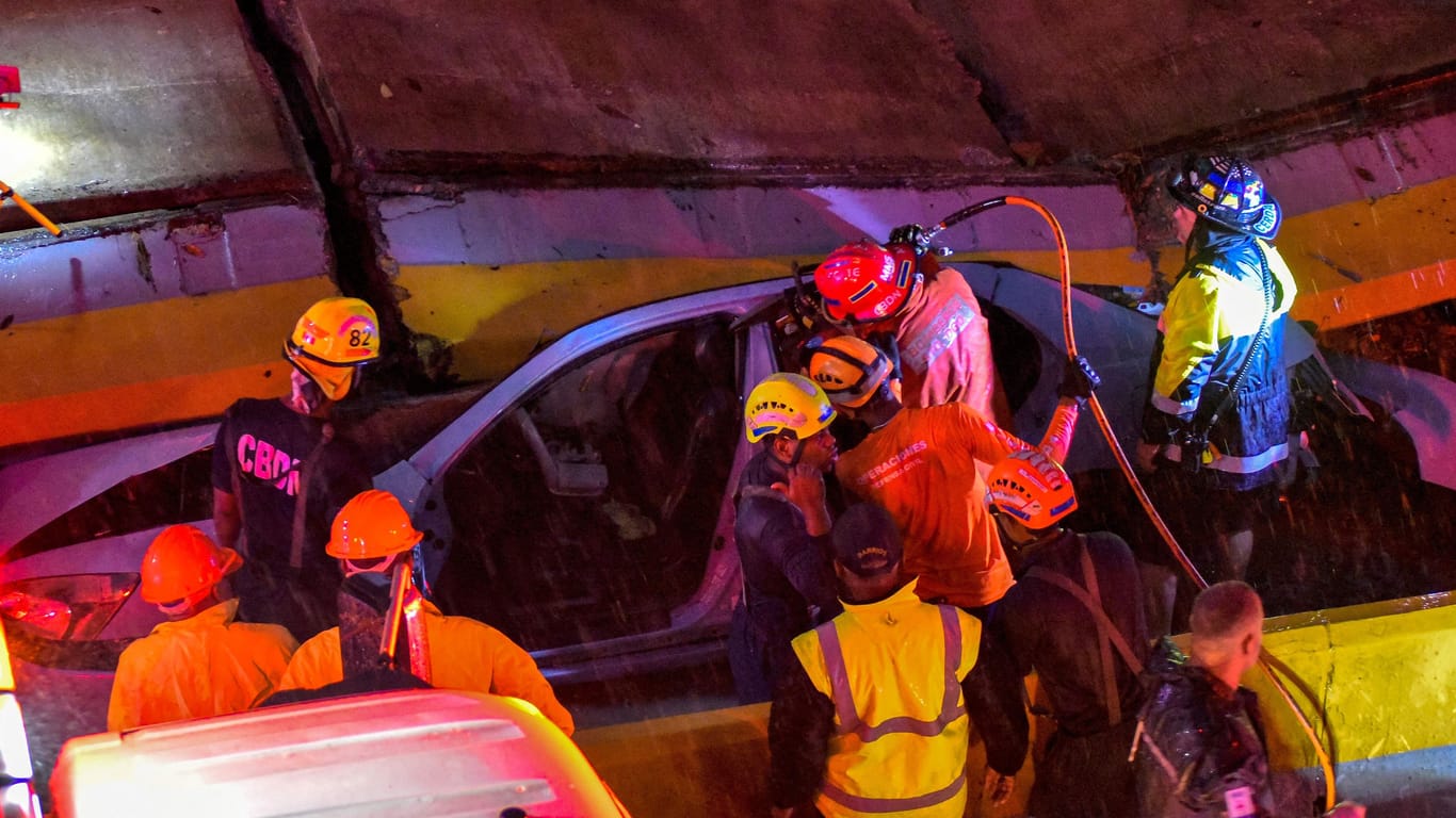 Feuerwehrleute suchen nach Überlebenden, nachdem eine zusammengebrochene Wand mehrere Autos unter sich begraben hatte. Allein bei diesem Unglück kamen neun Menschen ums Leben.
