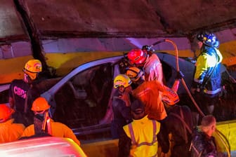 Feuerwehrleute suchen nach Überlebenden, nachdem eine zusammengebrochene Wand mehrere Autos unter sich begraben hatte. Allein bei diesem Unglück kamen neun Menschen ums Leben.
