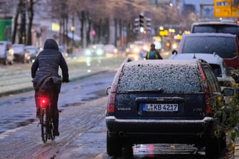 Eine Fahrradfahrerin ist bei Schneeregen unterwegs (Symbolbild): Auch in den kommenden Tagen kann es in vielen Teilen Deutschlands zu Schneeregen kommen.