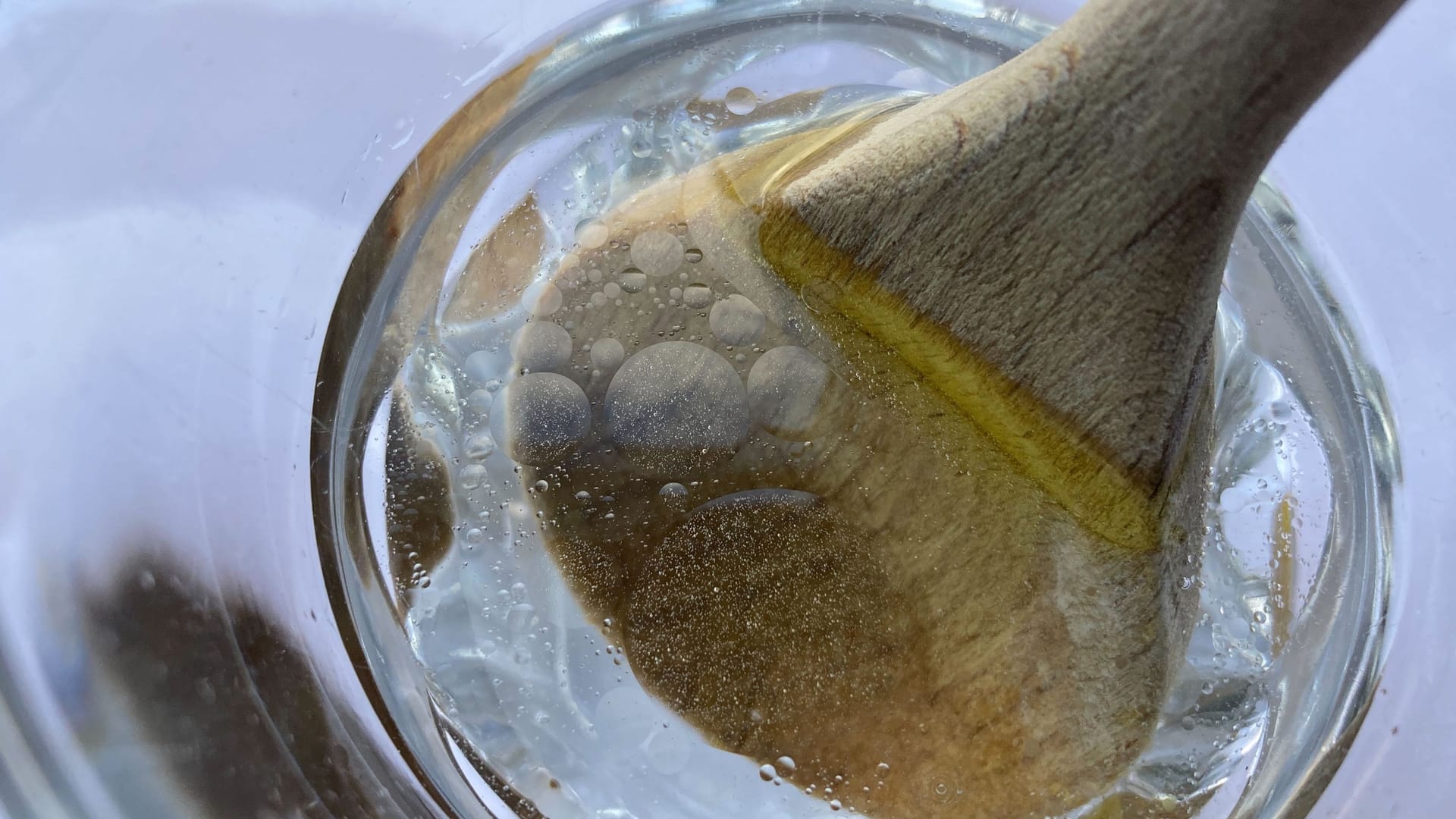 Holzlöffel: Schmutzpartikel lösen sich in heißem Wasser.