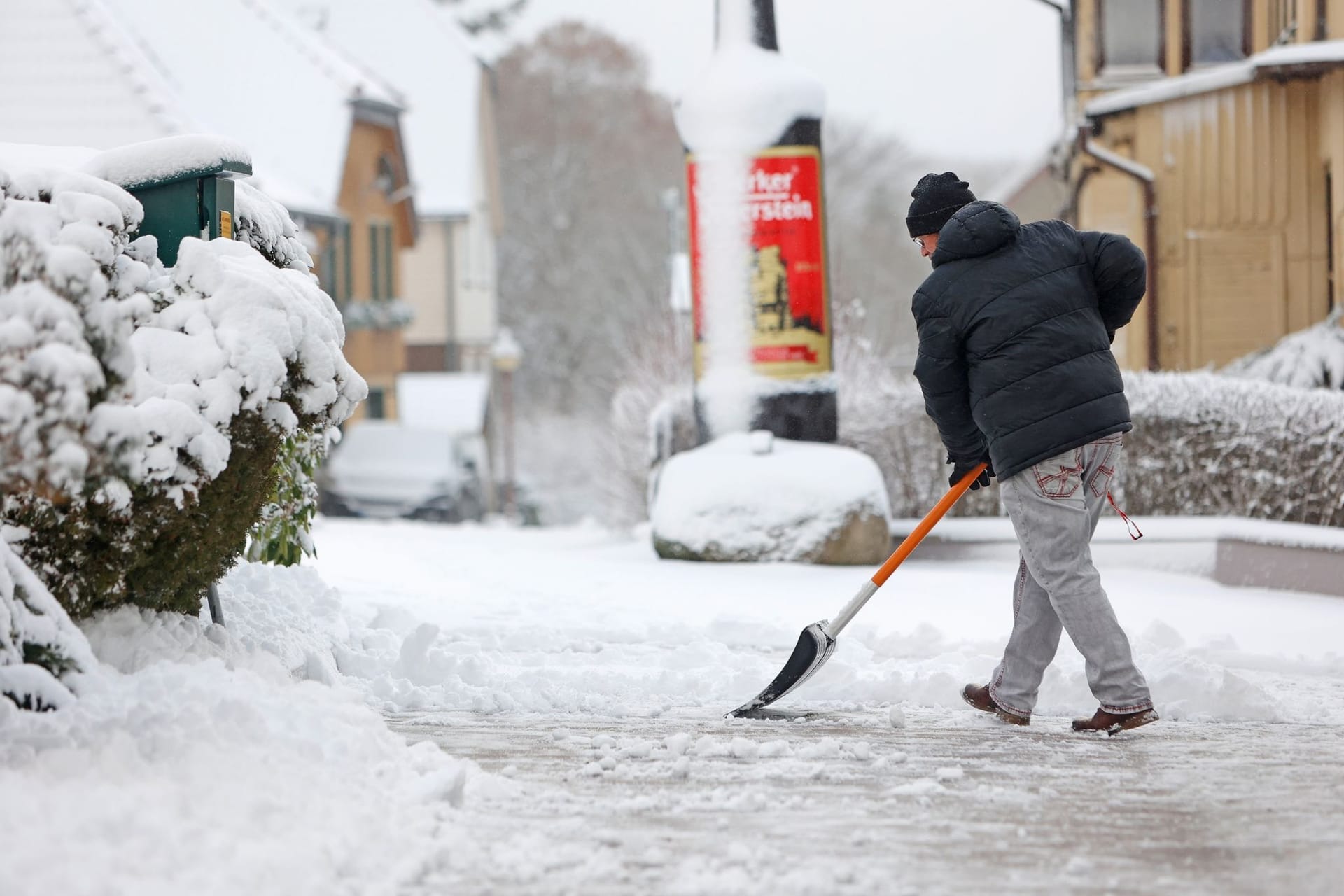 Eine Person schippt Schnee Eine Person schippt Schnee
