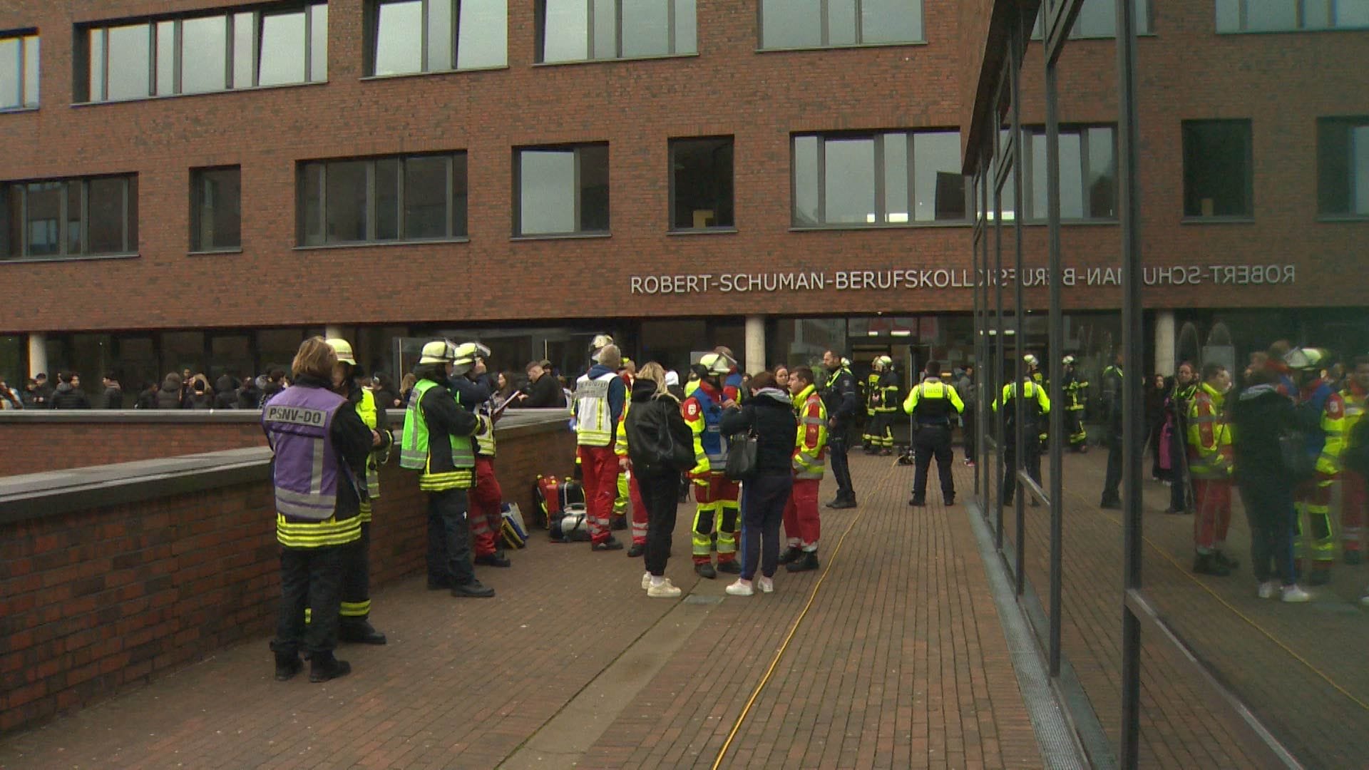 Einsatzkräfte der Feuerwehr vor dem Robert-Schuman-Berufskolleg: Feuerwehrleute durchlüfteten das Gebäude. Einsatzkräfte der Feuerwehr vor dem Robert-Schuman-Berufskolleg: Feuerwehrleute durchlüfteten das Gebäude.