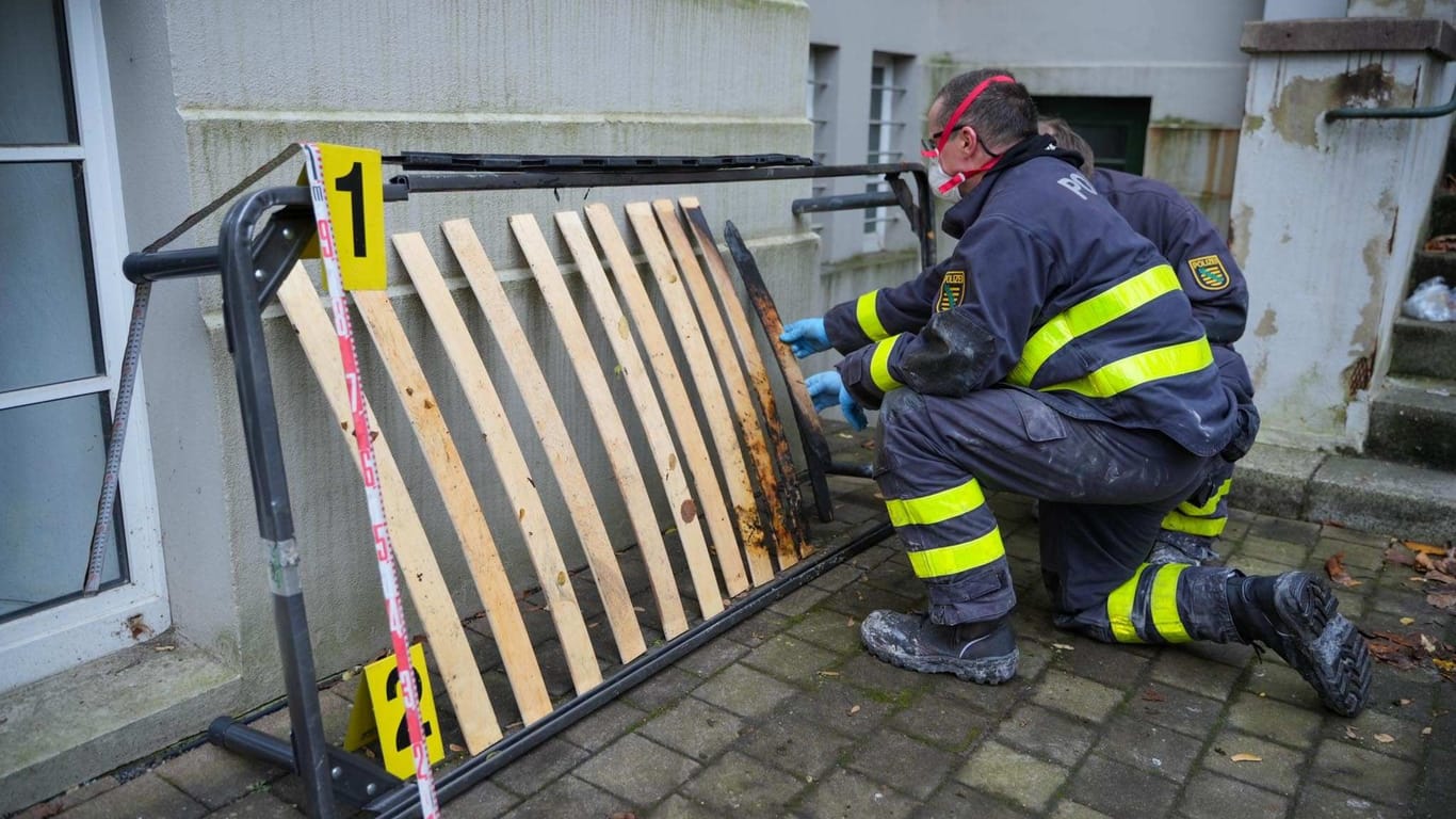 Spezialisten der Polizei untersuchen ein Bettgestell vor der Wohnung an der Gabelsbergerstraße: Die mutmaßliche Brandstifterin sitzt in U-Haft.