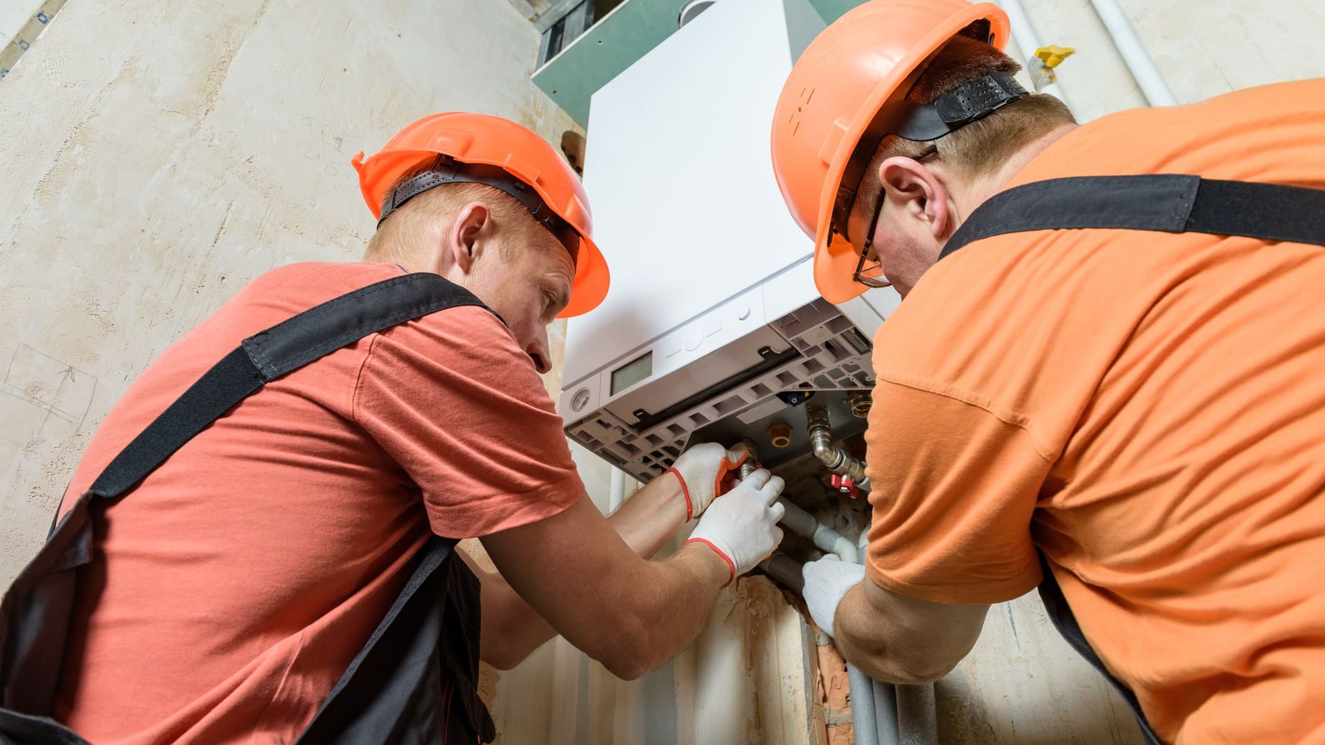 Heizungsinstallateure bei der Arbeit: Vor allem Eigentümer sollten sich mit dem GEG intensiv auseinandersetzen.