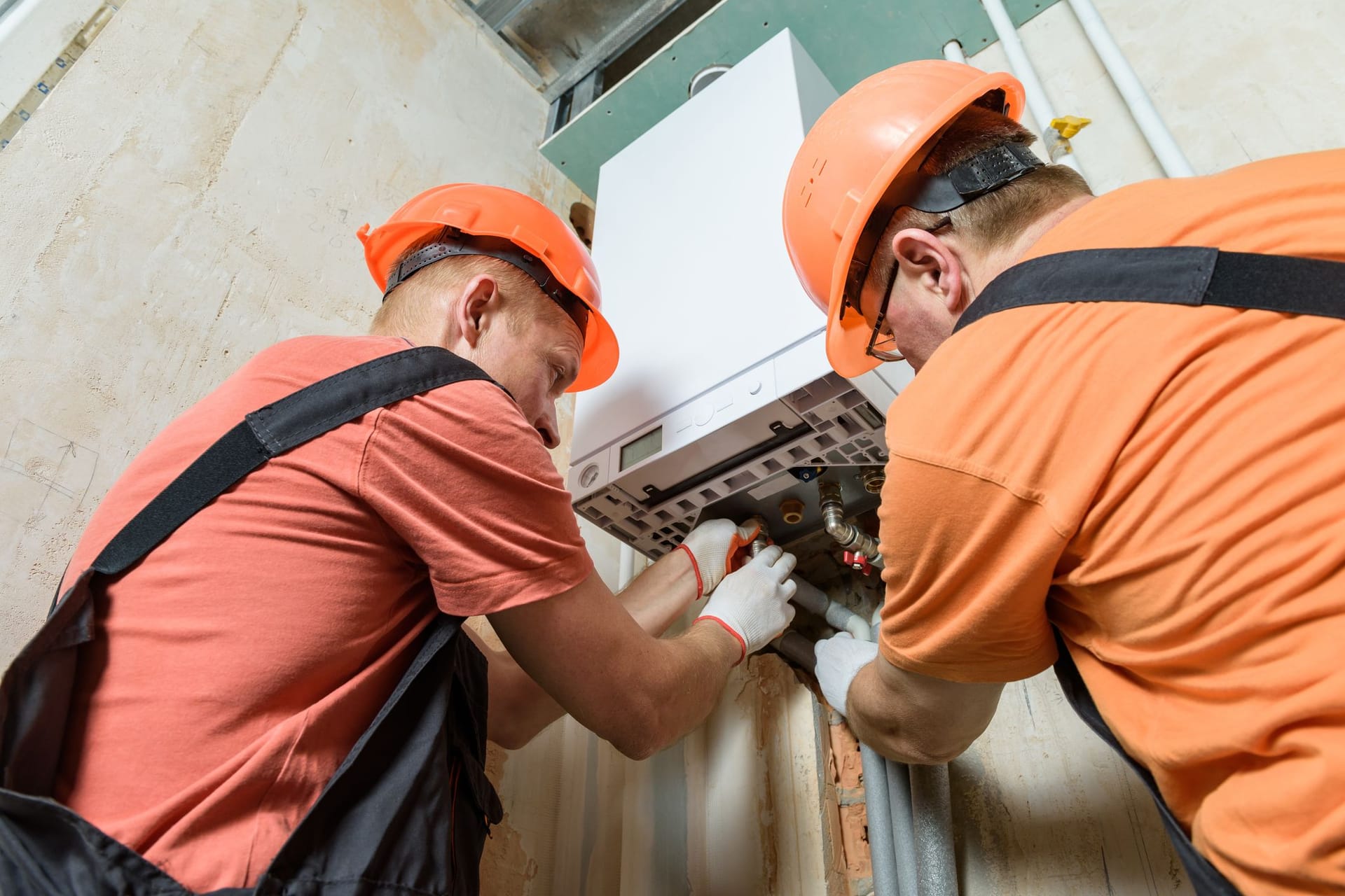 Heizungsinstallateure bei der Arbeit: Vor allem Eigentümer sollten sich mit dem GEG intensiv auseinandersetzen.