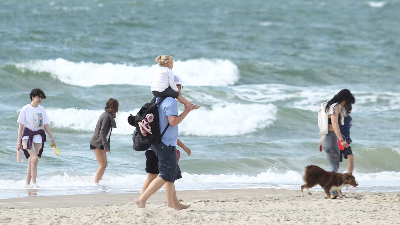 Urlauber an der Nordsee (Symbolbild): Ein Mann trägt am Strand seine Tochter auf dem Rücken.