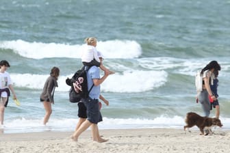 Urlauber an der Nordsee (Symbolbild): Ein Mann trägt am Strand seine Tochter auf dem Rücken.
