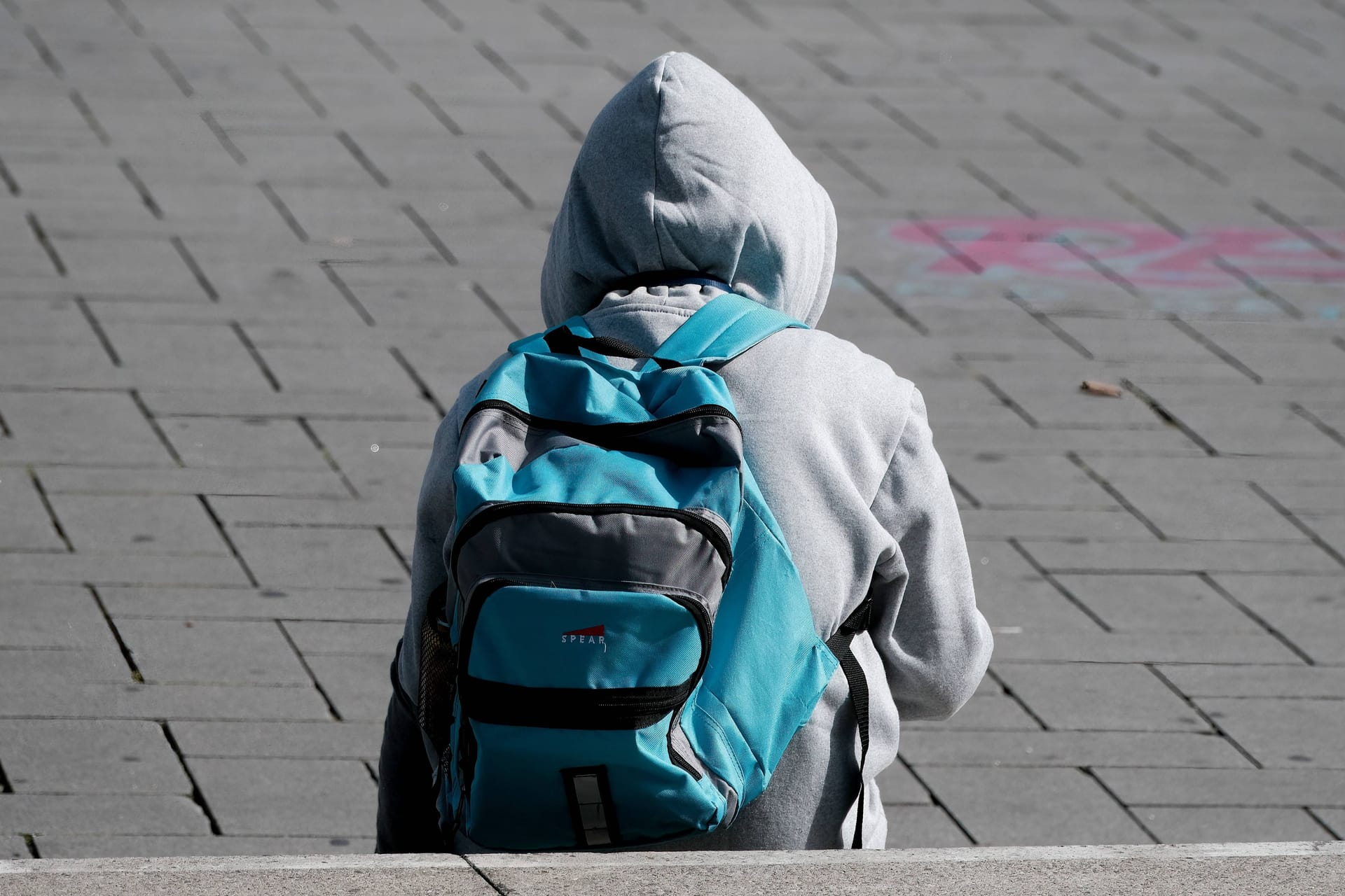 Schüler sitzt auf Schulhof (Symbolbild): In Baden-Württemberg wurde ein Schüler ins Krankenhaus geprügelt.