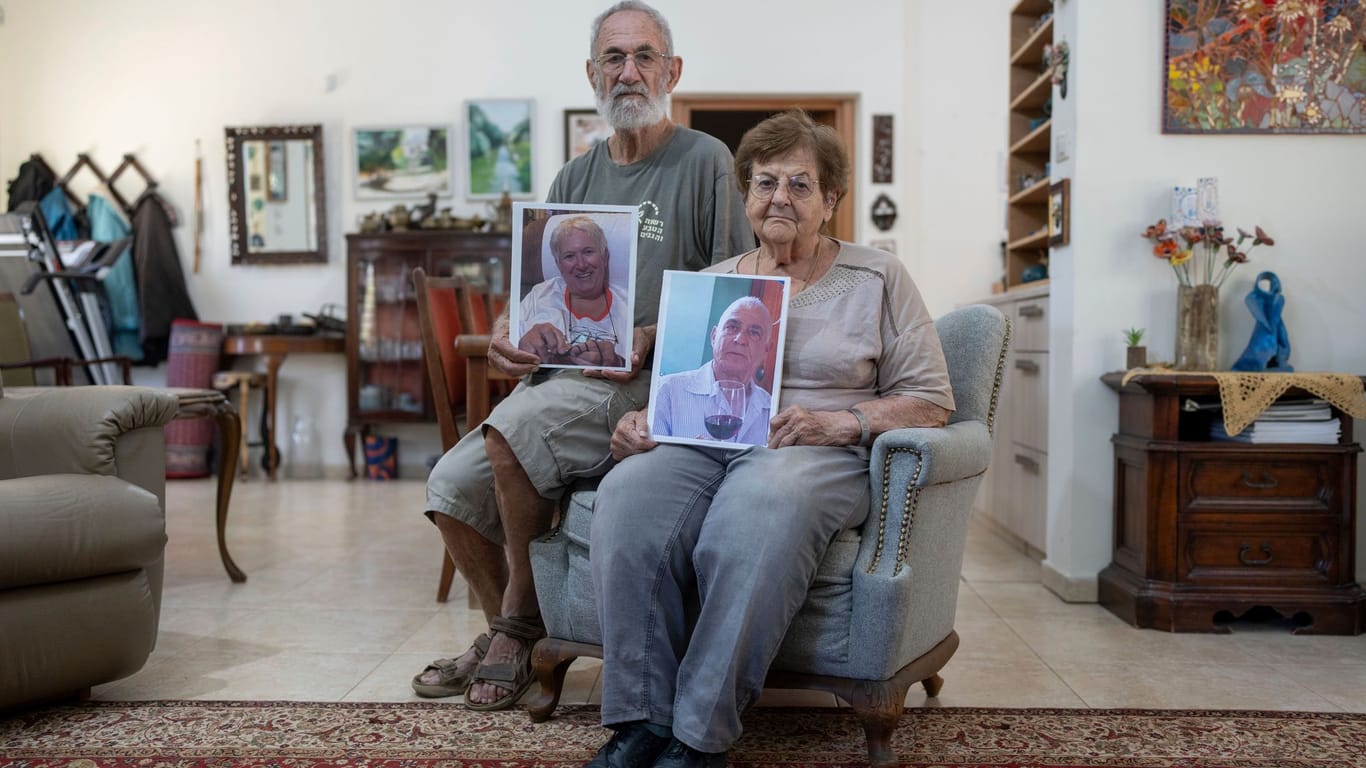 Channan Choen, Bruder von Margalit Mozes, und dessen Frau halten Bilder der entführten Frau und von Gadi Mozes.