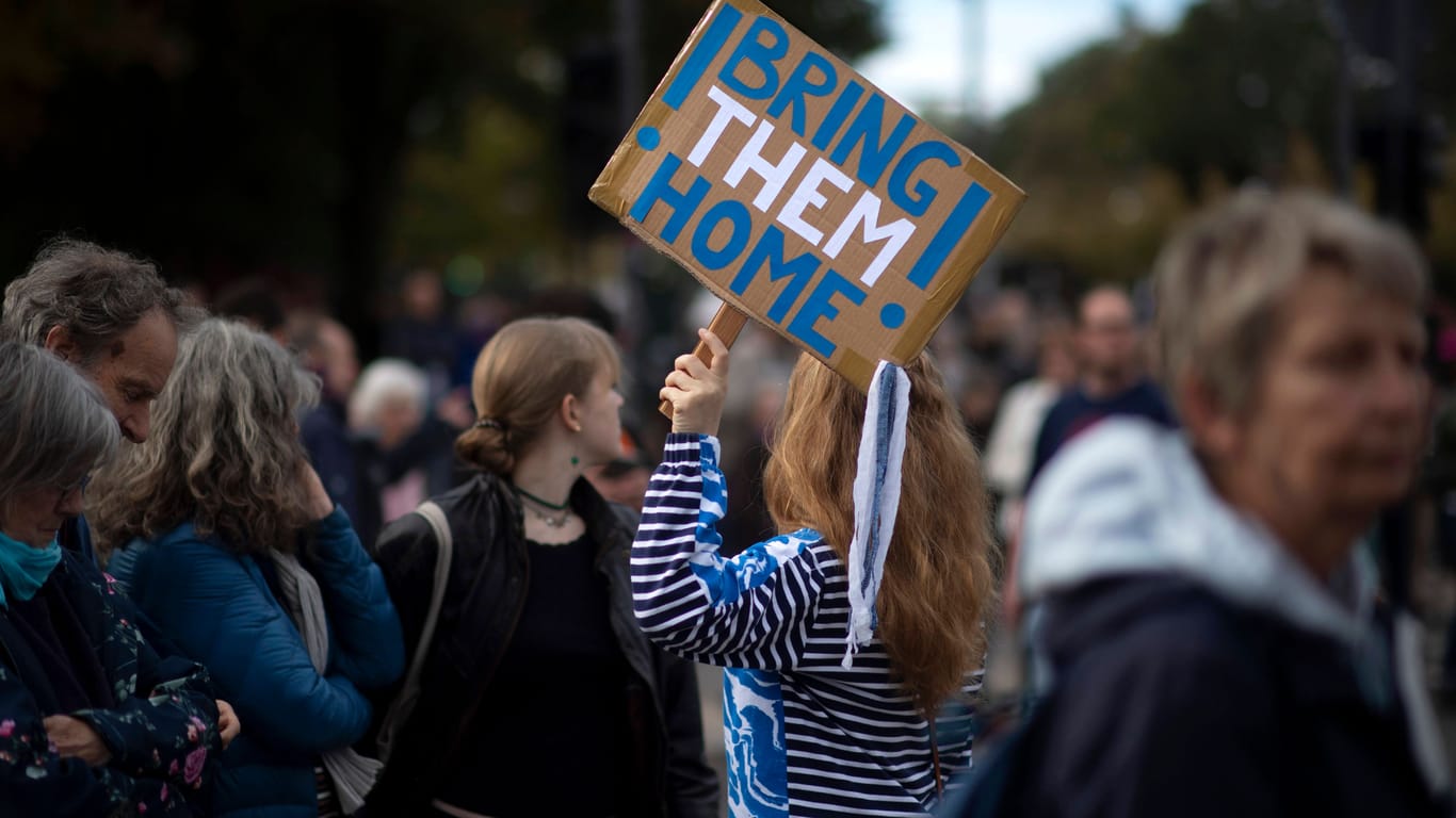 Die Teilnehmerin einer pro-Israel Kundgebung mit einem Schild "Bring them home" (Symbolbild): In Köln findet am Sonntag eine Solidaritätskundgebung statt.