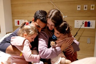 Raz (4), Vater Yoni Asher, Mutter Doron und Aviv (2) halten sich im Schneider-Hospital für Kinder im israelischen Petah Tikva in den Armen. Doron und die Kinder erhielten hier nach ihrer Freilassung aus der Geiselhaft einen Gesundheitscheck.