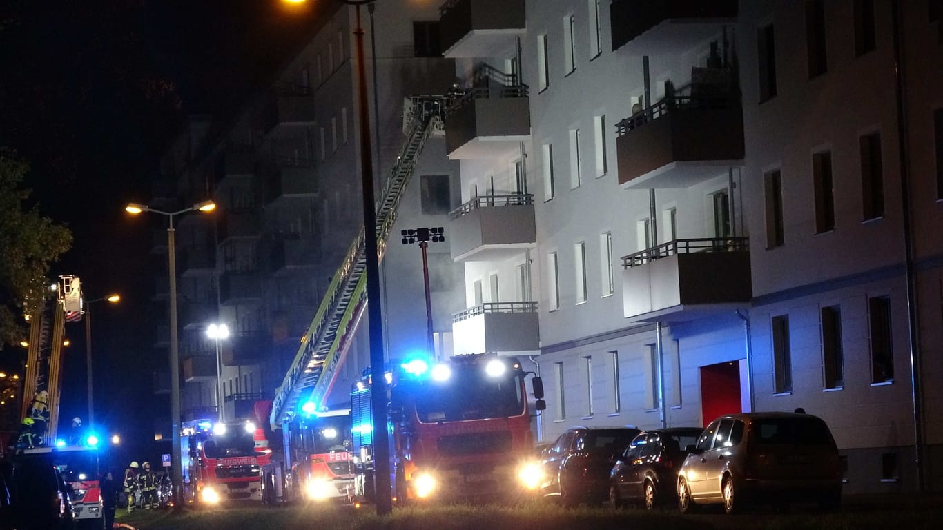Fahrzeuge der Feuerwehr stehen vor einem Haus in Leipzig: Die Brandursache ist derzeit unklar.