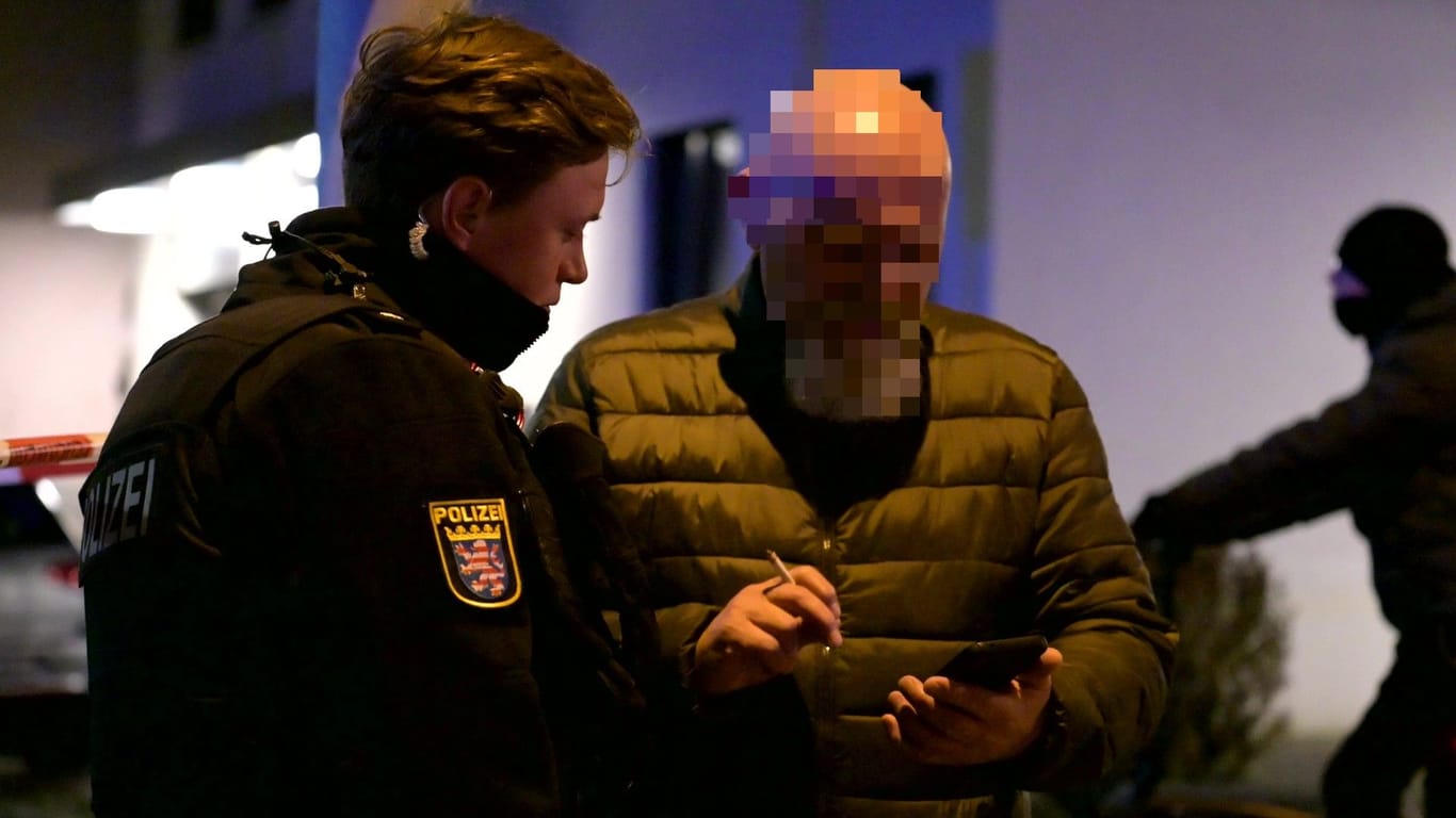 Ein Frankfurter Polizist schaut dabei zu, wie ein Gaffer Fotos der Unfallstelle von seinem Handy löscht.