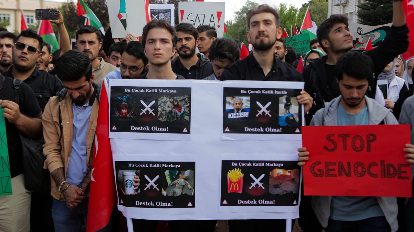 Pro-palästinensische Demonstranten halten ein Plakat, auf dem sie Mc Donalds, Coca-Cola und Starbucks in Verbindung mit israelischen Luftschlägen bringen (Archivbild): Das türkische Parlament hat Produkte von Coca-Cola und Nestle zuletzt verbannt.