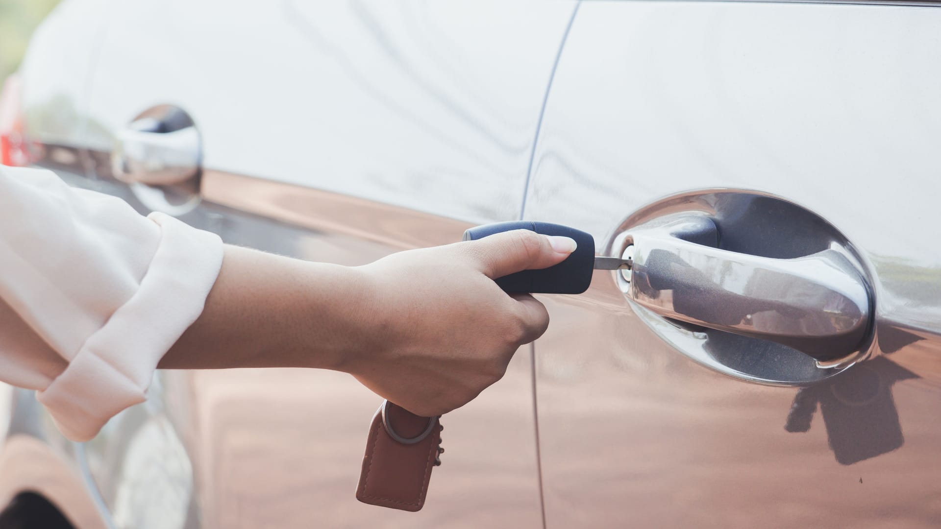 Eine Frau schließt ein Auto auf.